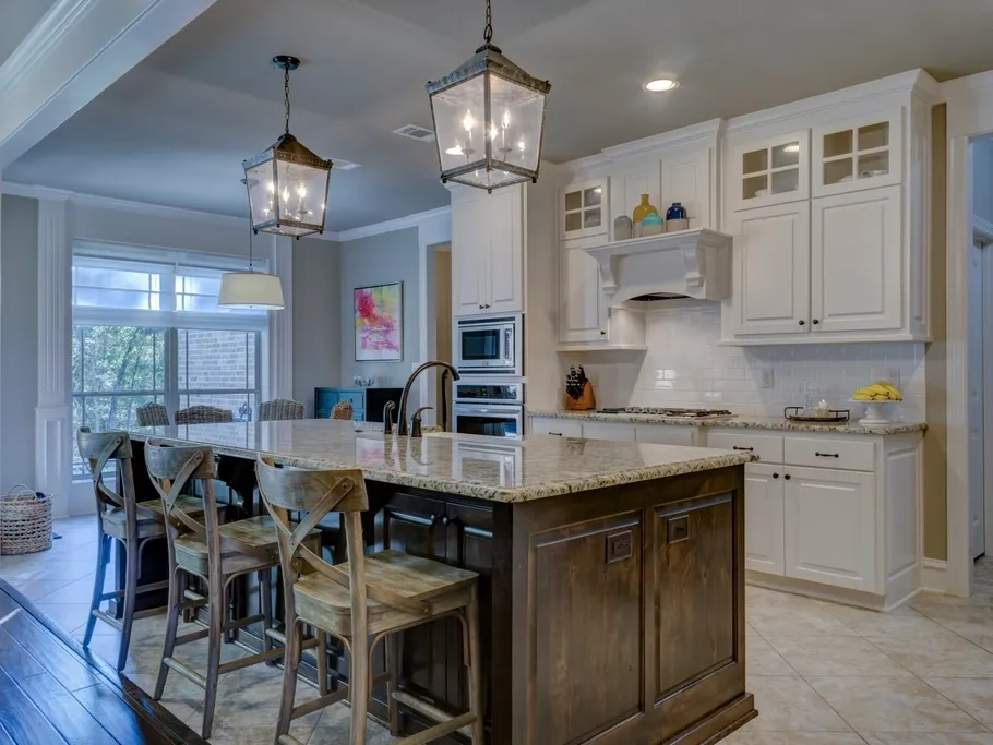 Finished kitchen with island, pendants, and white cabinets