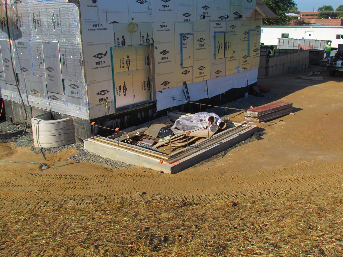 Foundation forms set beside a new home under construction